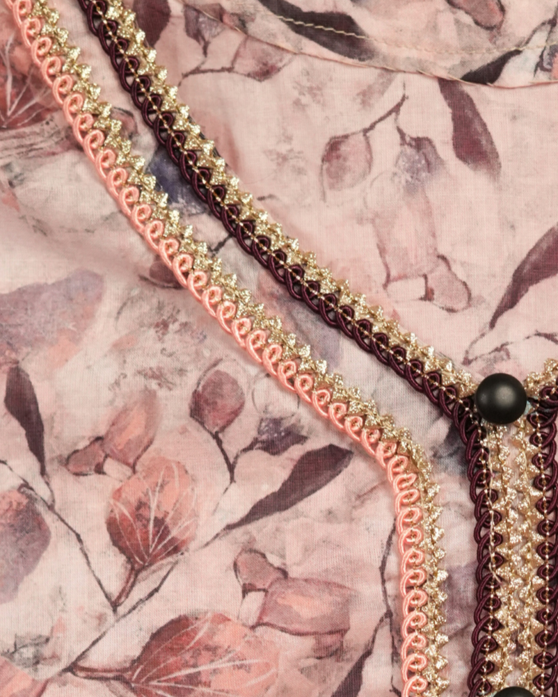 Floral patterned garment with decorative trim on a plain background